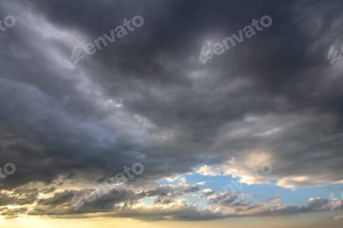 Preview: Sunset sky covered with dramatic storm puffy clouds before rain.