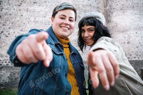 Preview: Women pointing your looking the camera outdoors