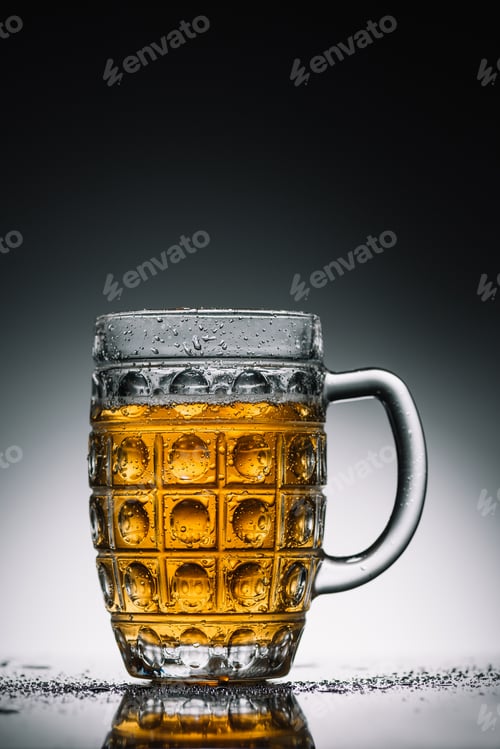 Preview: glass with light cold beer with bubbles on gray reflecting surface