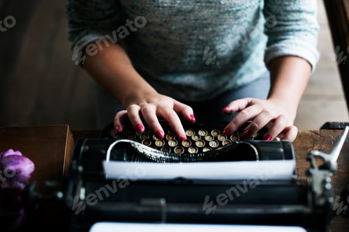 Preview: Woman typing vintage typewriter on wooden table