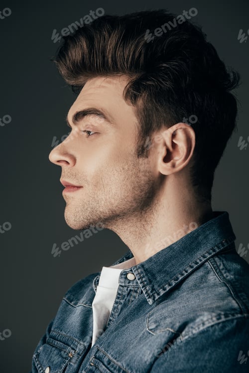 Preview: side view of handsome and brunette man in denim shirt isolated on black