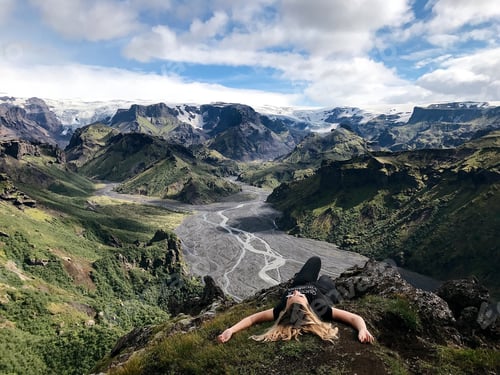 Preview: Woman Relaxing on Cliffside Overlooking Mountain Valley