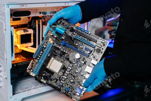 Preview: Closeup of technician holding motherboard during PC assembly in modern technology lab,