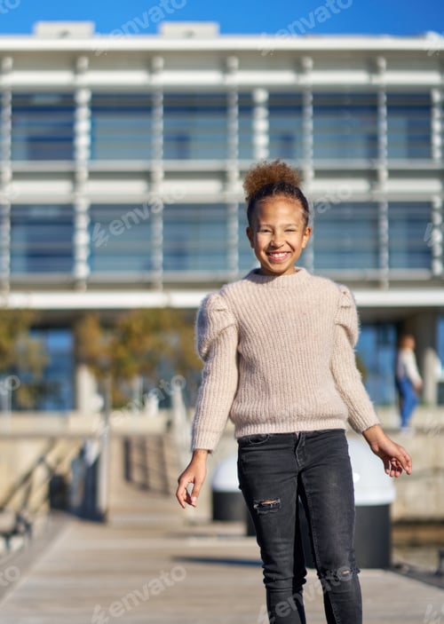 Preview: a girl with curly hair walks smiling in the street