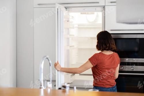 Preview: Housewife Looking Inside Of Empty Fridge While Standing In Kitchen