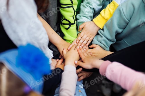 Preview: Team of children put hands together and unite to win game in playground. Summer holidays in camp