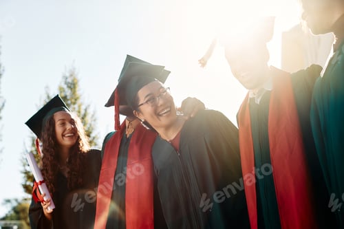Preview: Cheerful Asian graduate and her classmates having fun on their graduation day.