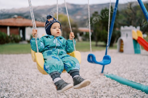 Preview: Little girl swings on a rope swing on the playground