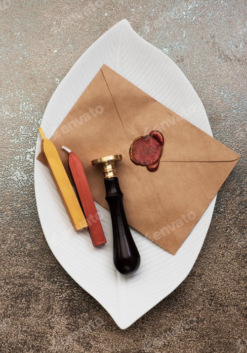 Preview: Envelope with a red wax seal on a tray, and a wax seal with wax candles