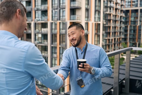 Visualização: Funcionários da empresa apertando as mãos durante o intervalo do café