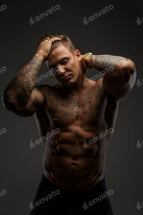 Preview: Muscular man with tattooes in deep shadows