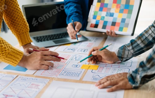 Preview: Close up view of UI developer team brainstorming on their project with laptop, smartphone