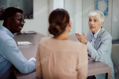 Preview: Mature female financial consultant having meeting with a couple in the office.
