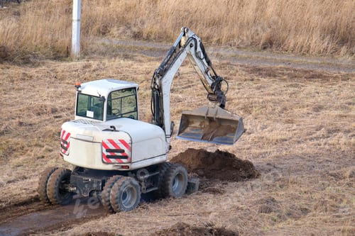 Preview: Earth moving tractor preparing place for future house foundation construction. Leveling soil for