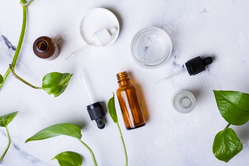 Preview: Glass bottles and jar for natural cosmetics on a white marble background