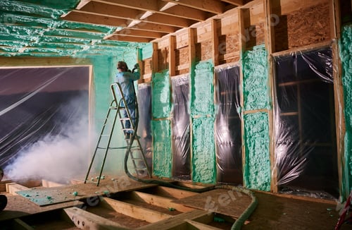 Preview: Worker spraying polyurethane foam for insulating wooden frame house.