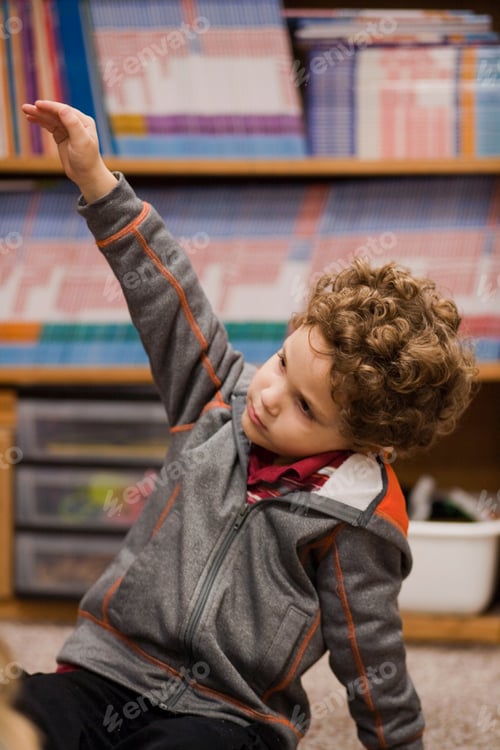 Preview: Toddler raising hand in classroom