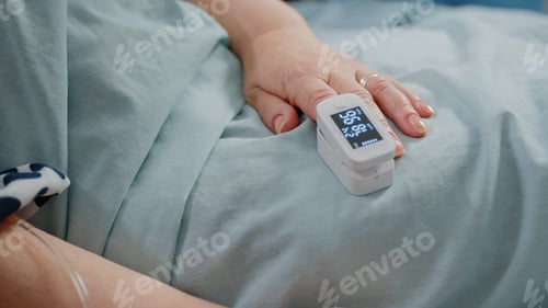 Preview: Close up of hand of aged patient with oximeter in bed