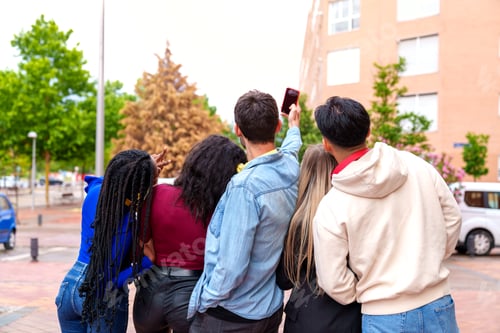 Preview: Backlit Urban Selfie: Five Friends Embrace Sunset Glow, Casual Attire & Colorful Headphones