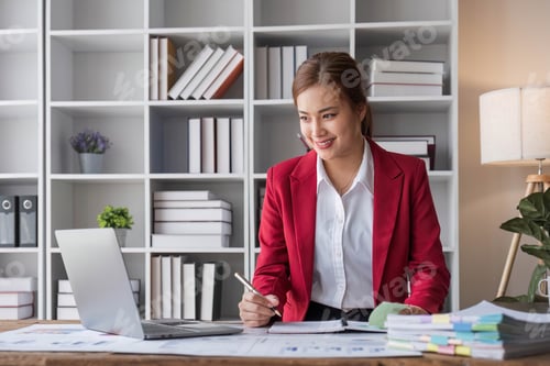 Preview: Attractive and inspired asian businesswoman sits at her desk, looking out the window, and