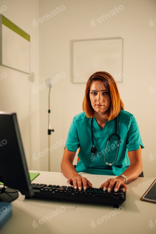 Preview: Young female doctor at computer in medical office clinic work.