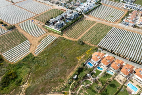 Preview: Aerial drone view of greenhouses in a row, covered with a transparent film of growing vegetables and