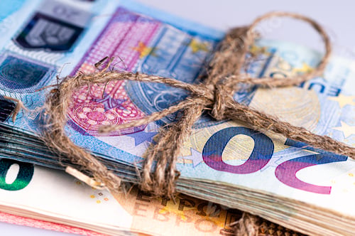 Preview: stack of euro banknotes tied with burlap string, close-up, wealth and prosperity concept