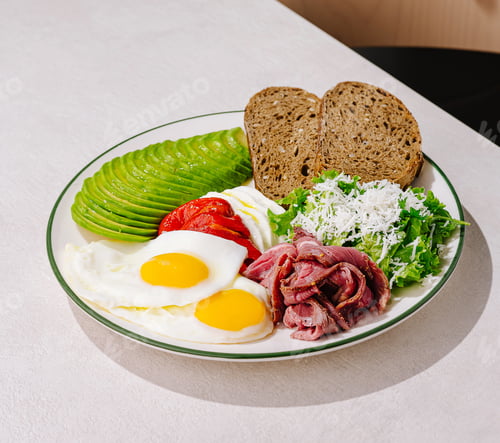Preview: Healthy breakfast plate featuring eggs, avocado, and salad in bright setting