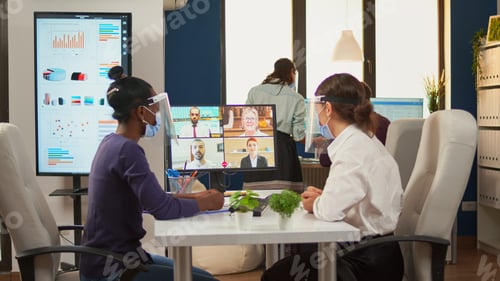 Preview: Black woman and entrepreneur with protective masks having videocall