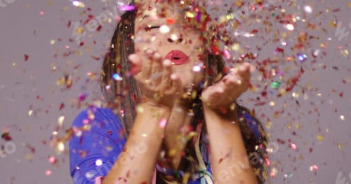 Preview: Cute young woman blowing confetti
