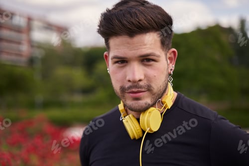 Preview: portrait of a latin man looking at the camera with yellow helmets around his neck