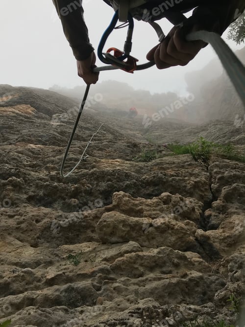 Preview: Vertical shot of a hiker with a rope on the mountains