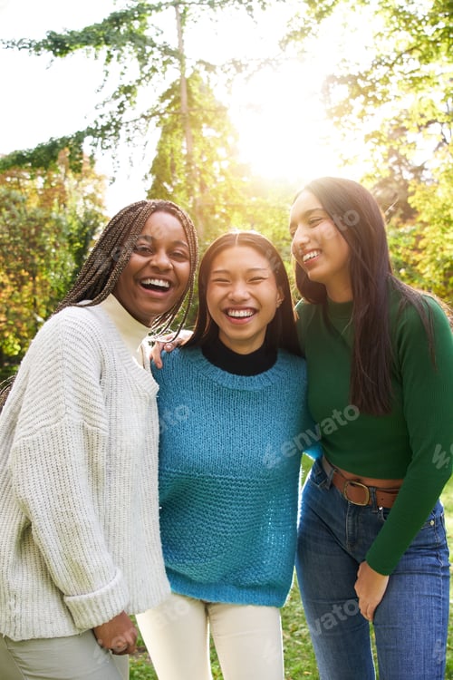 Preview: Vertical Portrait of three girls outside looking at camera. Friends multi-ethnic groups of people