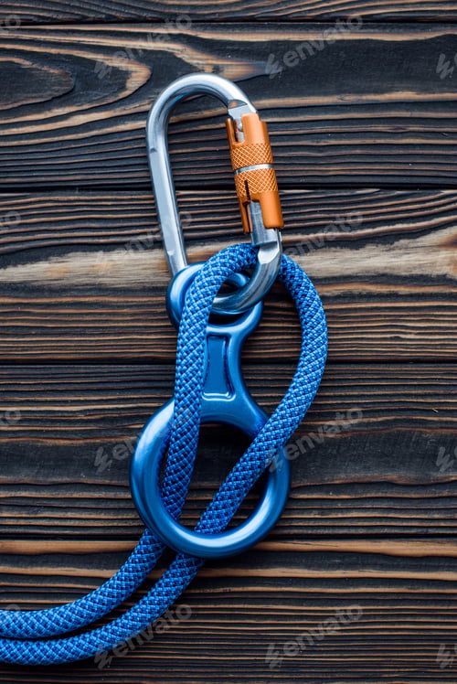 Preview: Simple lock. Isolated photo of climbing equipment. Parts of carabiners lying on the wooden table