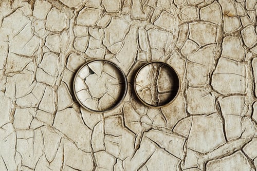 Preview: stylish wedding rings on old cracked paint on the background of a window, love concept