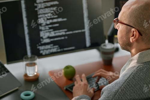 Preview: Middle Aged Caucasian Man Coding on Computer in Modern Office Setting