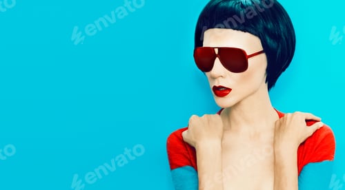 Preview: brunette model with fashion haircut and sunglasses on a blue bac