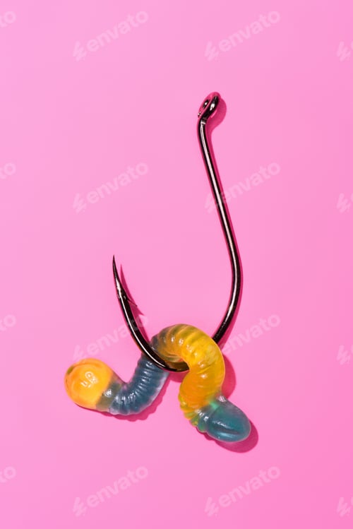 Preview: colorful gummy worm on fishing hook on pink