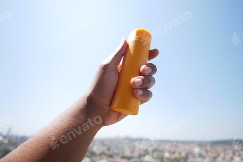 Preview: Close up of person hand using sunscreen cream outdoor
