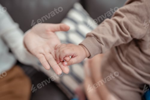 Preview: Hands holding of mother parent soft touch newborn baby fingers love family concept. Infant child por