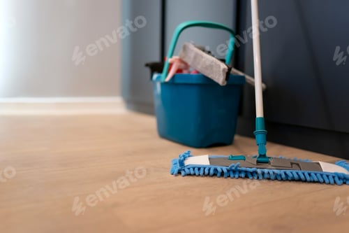 Preview: Cleaning concept. Mop and plastic bucket with cleaning products on the floor