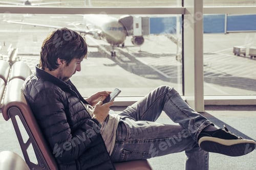 Preview: Man use smartphone at the airport waiting hall.