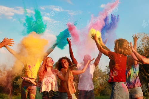 Preview: Happy friends having fun with colorful powder dyes outdoors. Holi festival celebration
