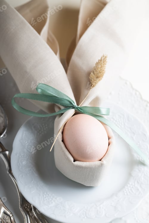 Preview: Easter eggs painted in delicate Easter colors in a table setting with dried flowers