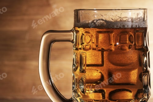 Preview: Glass of beer over wooden surface