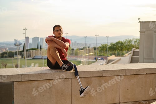 Thoughtful Man with Prosthetic Leg Sits Outdoors