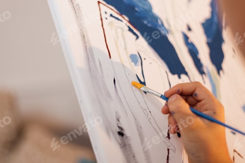Preview: A boy draws a picture with paints and a brush