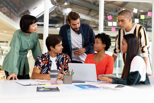 Preview: Front view of diverse business people discussing over laptop in the conference room at office