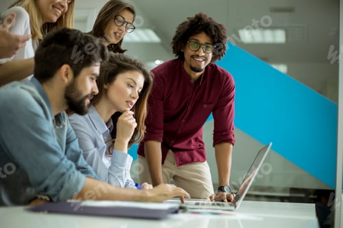 Preview: Group of young multiethnic business people working and communicating together in creative office