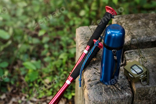 Preview: Trekking pole, water bottle and compass isolated on a rock outdoor